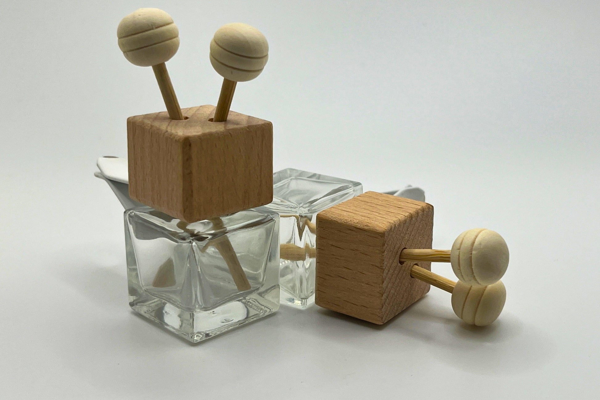 Customizable car vent diffuser with a natural wooden cap and sleek glass bottle. Handcrafted, offering long-lasting, personalized fragrances for cars, small spaces, or on-the-go aromatherapy. Elevate your drive with a touch of elegance and freshness.