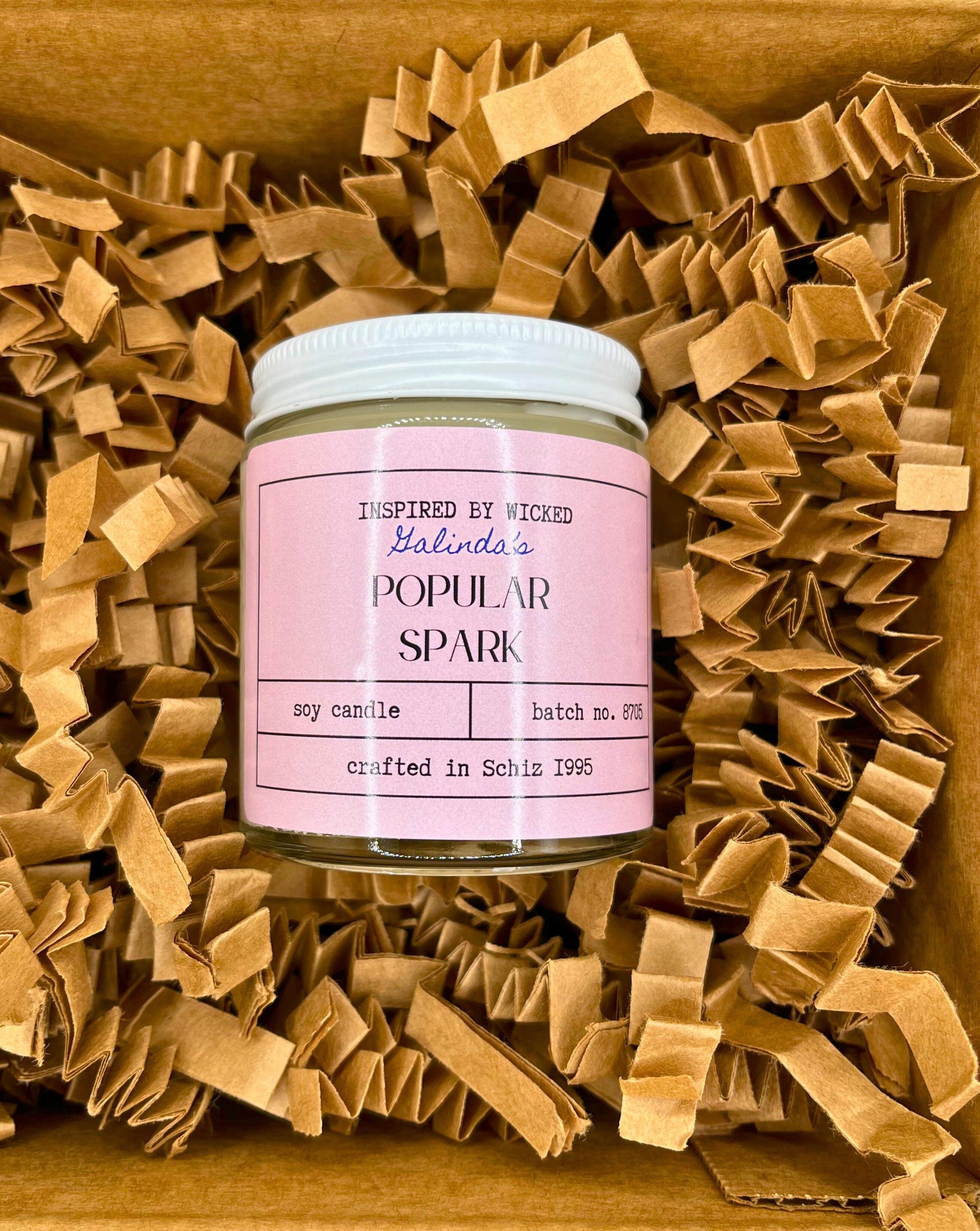Handcrafted soy candle inspired by Wicked's Galinda, featuring a Popular Spark pink label. Infused with enchanting fragrances, it adds a touch of magic and whimsy to your space. Perfect for unique gifting or personal enjoyment.